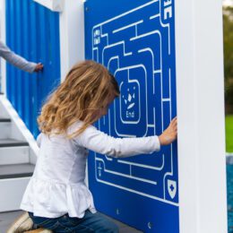 This image shows a child using our finger maze on our commercial playground.