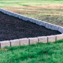 This image shows our rubber mulch tucked up against a playground border.